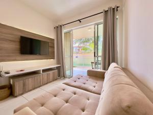 a living room with a large couch and a tv at Palm Beach | Porto das Dunas - CE in Mangabeira