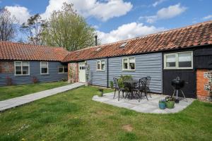 l'arrière-cour d'une maison avec une table et des chaises dans l'établissement Natterjack by Winterton Cottages, à Winterton-on-Sea