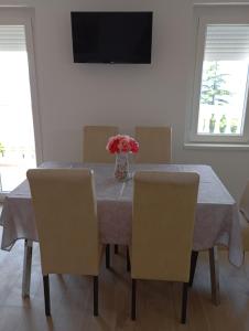 ein Esstisch mit einer Vase mit Blumen darauf in der Unterkunft House Daniela in Omišalj