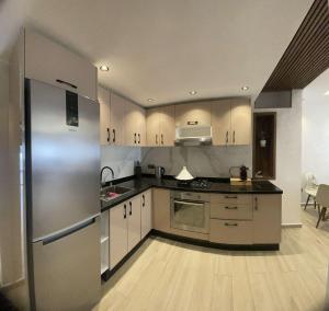 a kitchen with stainless steel appliances and wooden floors at Appartement vue sur Tower Hassan in Rabat