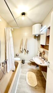 a bathroom with a sink and a tub and a toilet at Tonale Ski-in AlpView Studio in Passo del Tonale +27 photos