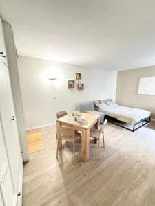 a living room with a table and a bed at Tonale Ski-in AlpView Studio in Passo del Tonale
