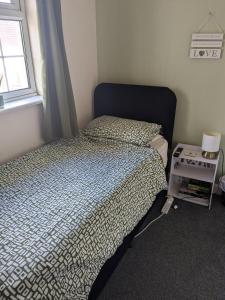 a small bedroom with a bed and a window at Small but bright single room not far from City Centre in Leicester