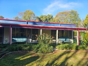 a house with two blue chairs on a yard at King Sanctuary in Centurion +16 photos