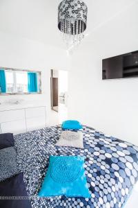 a bedroom with a blue and white floor with a chandelier at Apartament Nadwiślańska in Krakow