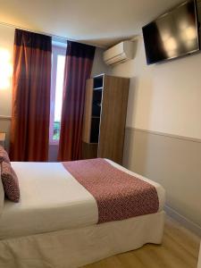 a hotel room with a bed and a window at H&ocirc;tel de France Quartier Latin in Paris