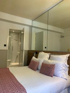 a bedroom with a large bed with mirrors on the wall at Hôtel de France Quartier Latin in Paris