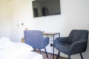 a room with two chairs and a table and a tv at Johouse Zingst Johouse Zimmer 04 in Zingst