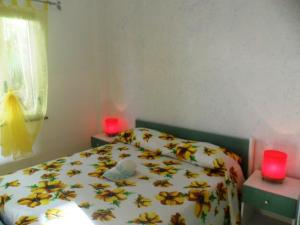 a bedroom with a bed and two red candles at Apartment Dependance-2 by Interhome in Santa Maria