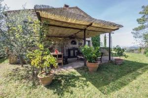 a pergola with a table and some plants in a yard at Il Casolare delle Fiabe in Casole dʼElsa