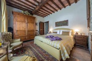 a bedroom with a large bed and a chair at Il Casolare delle Fiabe in Casole dʼElsa