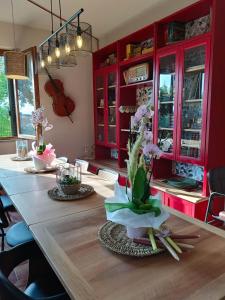 a dining room with red cabinets and a table with flowers at Sweet Emily B&B in Montelupo Fiorentino +29 photos