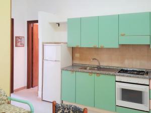 a kitchen with blue cabinets and a white refrigerator at Apartment Dependance-1 by Interhome in Santa Maria +3 photos