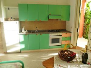 a kitchen with green cabinets and a table at Apartment Dependance-3 by Interhome in Santa Maria +3 photos