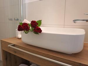 a white bowl with roses on a counter in a bathroom at Apartment Hirsch by Interhome in See