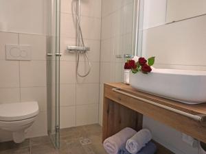 a bathroom with a sink and a toilet and a shower at Apartment Hirsch by Interhome in See +24 photos