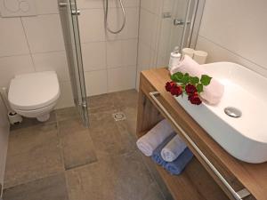 a bathroom with a sink and a toilet and a shower at Apartment Hirsch by Interhome in See +24 photos