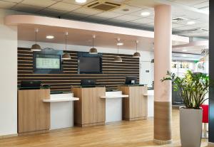 un bureau avec un hall d'entrée avec une télévision au mur dans l'établissement B&B HOTEL Orly Rungis Aéroport 3 étoiles, à Rungis