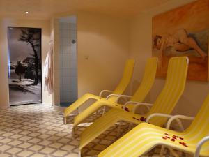 a group of yellow chairs in a waiting room at Apartment Hirsch by Interhome in See