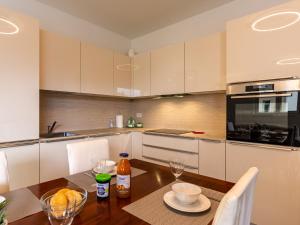 a kitchen with a wooden table and a kitchen with white cabinets at Apartment Luna by Interhome in Gravedona