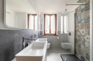 a white bathroom with two sinks and a shower at The Family Stone House Holidays Apartaments Dolomiti Cortina in Venas +70 photos