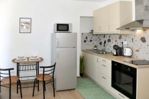 a kitchen with a white refrigerator and a table at Captain theo apartment Annoula in Lefkímmi