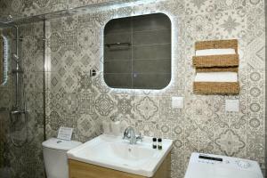a bathroom with a sink and a mirror and a toilet at Captain theo apartment Annoula in Lefkímmi +13 photos
