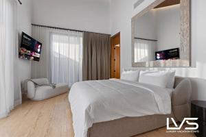 a white bedroom with a large bed and a mirror at Zen Oasis Villa at Casa de Campo in La Romana +80 photos