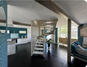 a living room with a staircase and a kitchen at Charmante maison comme chez soi in Saint-Amand-sur-Fion
