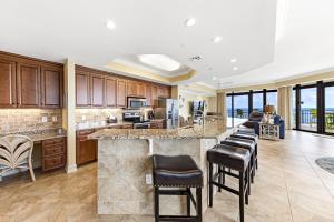 an open kitchen with a large island with bar stools at The Oasis at Orange Beach in Orange Beach