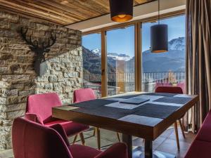 a dining room with a table and pink chairs at Holiday Home Jagd - Chalet by Interhome in Sölden