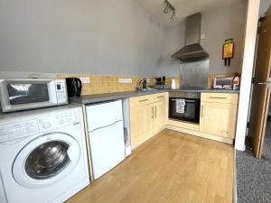 a kitchen with a washing machine and a microwave at Super Central Apartment in Heart of the City in Bristol