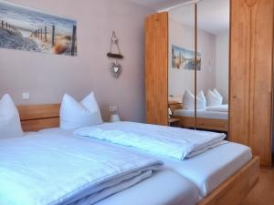 a bedroom with two beds and a mirror at Appartementhaus Bayern Residenz in Bad Füssing