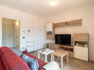 a living room with a red couch and a tv at Apartment Re16 Regina by Interhome in Gravedona