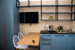 a kitchen with a table and a tv on a wall at Divine House amalfi coast in Albori