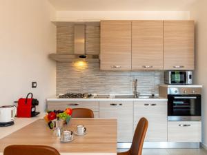 a kitchen with wooden cabinets and a wooden table at Apartment Re16 Regina by Interhome in Gravedona +17 photos