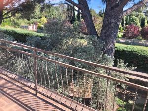 a wooden fence with a tree in the background at La Respelido studio ds maison campagne in Cabannes