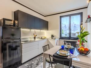 a kitchen with white cabinets and a table and chairs at Apartment Nonna Grazia by Interhome in Lenno