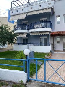 a blue fence in front of a building at Jenny's Holiday Villas in Polychrono