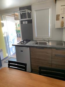 a kitchen with a sink and a stove and a window at OPHEA 2 Personnes in Limeuil