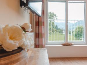 a living room with a window and a vase with flowers at Holiday Home Rübezahl-3 by Interhome in Bad Hofgastein