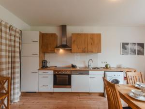 a kitchen with white appliances and a wooden table at Holiday Home Rübezahl-3 by Interhome in Bad Hofgastein