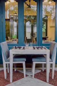 a wooden table with two chairs and a table and a table and chairs at Still Waters Artistry in Negombo