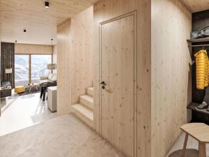 a room with a wooden door and a living room at Apartment Hideaway Planneralm by Jufa Hotels-2 by Interhome in Donnersbach