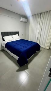 1 dormitorio con cama azul y manta azul en Diamond Flats 305 - São Lourenço, en São Lourenço