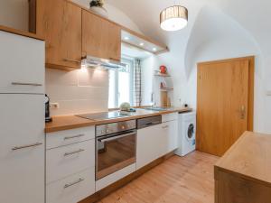 Una cocina con gabinetes blancos, fregadero y lavavajillas. en Apartment Rübezahl-1 by Interhome, en Bad Hofgastein