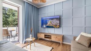 ステグナにあるSTEGNA PARK II blisko plaży Apartamenty Piamolaの青い壁にテレビ付きのリビングルーム