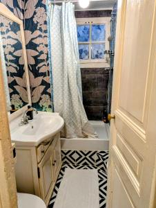 a bathroom with a sink and a shower curtain at Opera Louvre Holiday Apartment in Paris