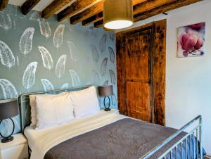 a bedroom with a bed and a wall with flowers at Opera Louvre Holiday Apartment in Paris
