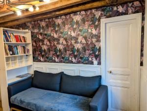 a living room with a blue couch and a wall at Opera Louvre Holiday Apartment in Paris